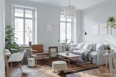 Salon moderne et lumineux avec de grandes fenêtres, canapé gris, fauteuil en cuir brun, table basse en bois, plusieurs plantes, sol en bois en chevrons et tapis décoratif.